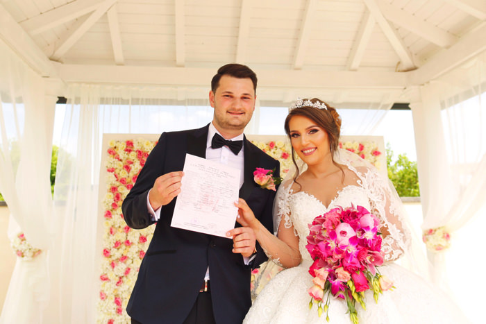 結婚証明書を手にして微笑む新郎新婦