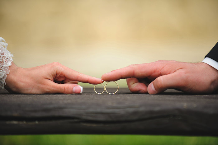 結婚指輪を触る新郎新婦の手元イメージ