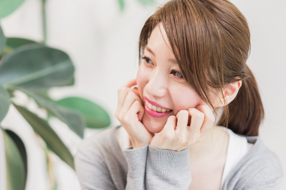 顎に手を添えて夫を見つめる女性