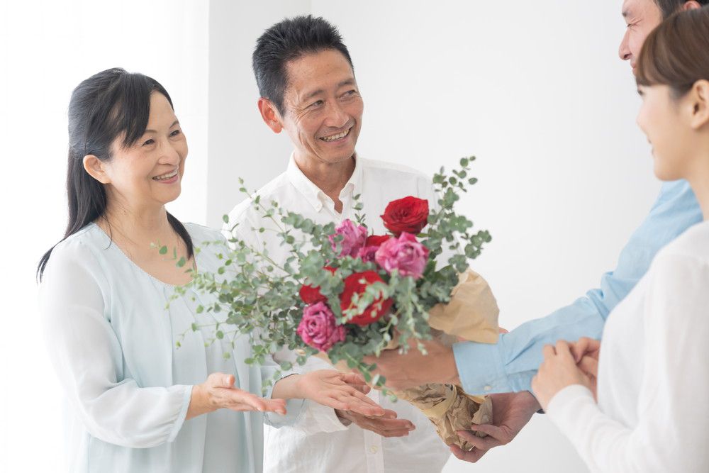 親に花束を渡している新婚夫婦