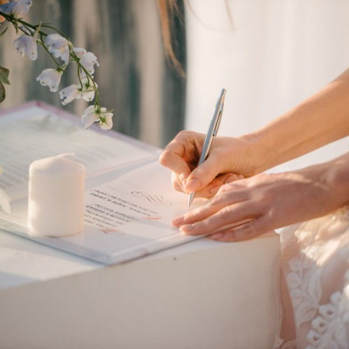 the bride in a wedding dress signs in the contract close up