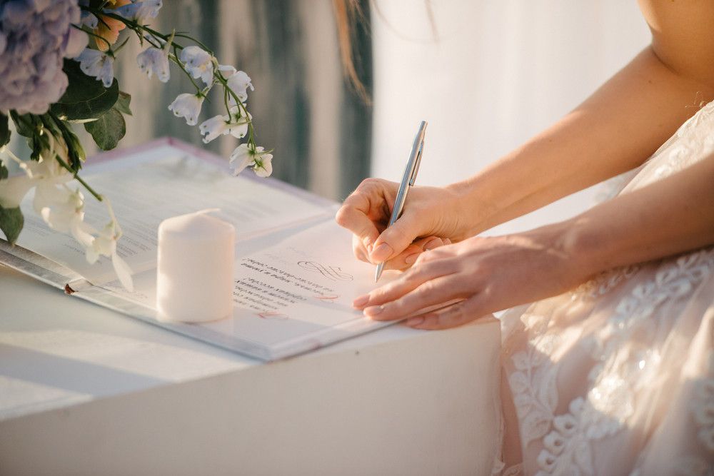 the bride in a wedding dress signs in the contract close up