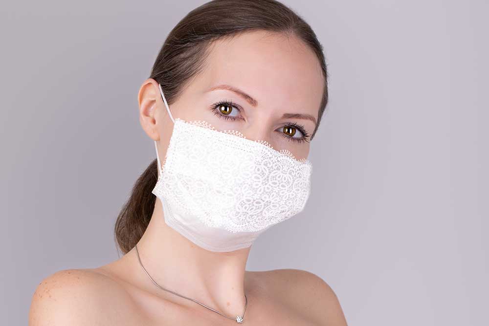白いレースの飾り付きマスクを着用している女性
