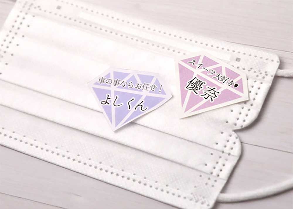 ゲスト名を記載したマスクに貼れるオリジナルマスクシールを貼っている不織布マスク