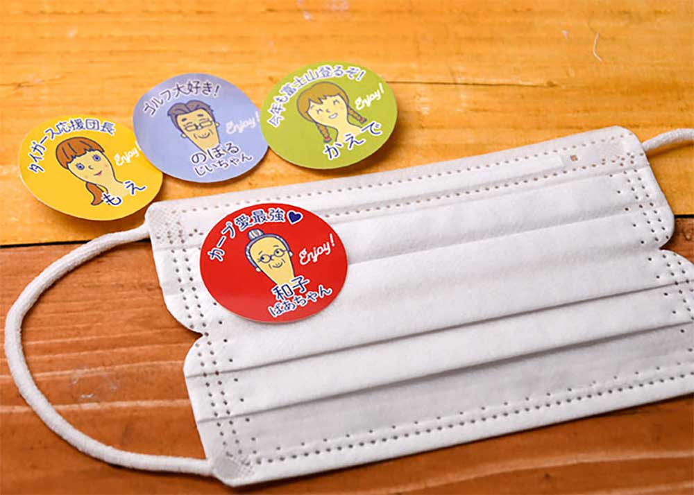 ゲストの似顔絵イラスト入りマスクに貼れるオリジナルマスクシールを貼っている不織布マスク