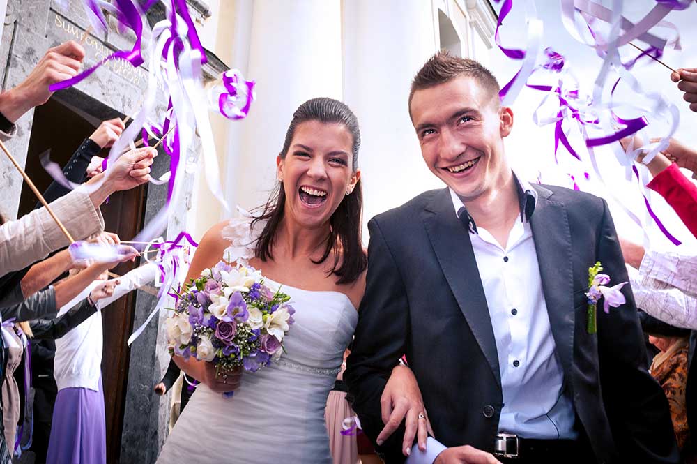 紫と白のリボンワンズで祝福される新郎新婦