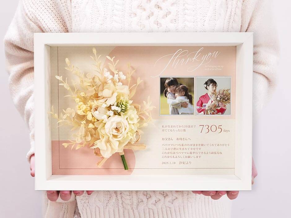 写真2枚入りのブーケ付き子育て感謝状を持っている
